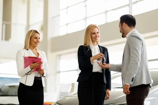 Araba anahtarını vererek saleswomen — Stok fotoğraf