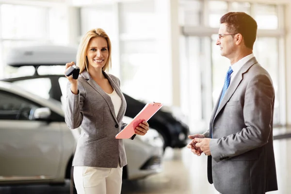 Verkäuferin gibt Autoschlüssel ab — Stockfoto