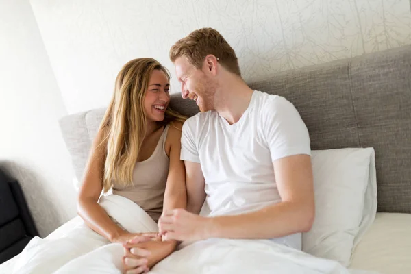 Casal deitado na cama de manhã — Fotografia de Stock