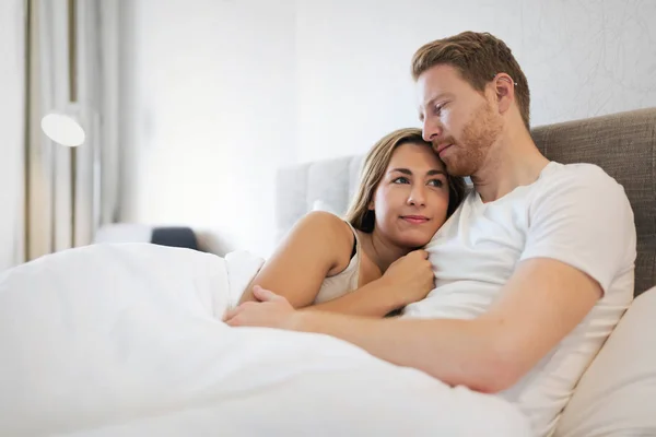 Vackra par ligger i sängen på morgonen — Stockfoto