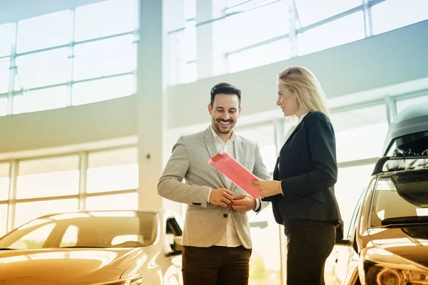 Beautiful blonde woman selling cars — Stock Photo, Image