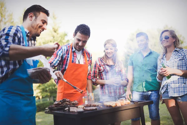 Lykkelige venner som nyter grillfest – stockfoto