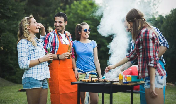 Felices amigos disfrutando de la barbacoa — Foto de Stock