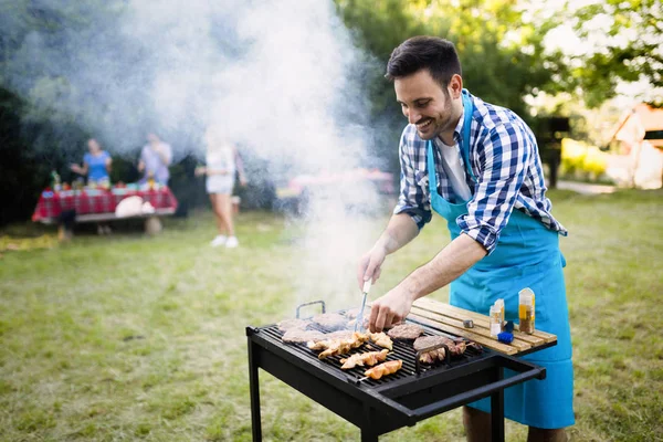 Handsome man grilling meat — Stock Photo, Image