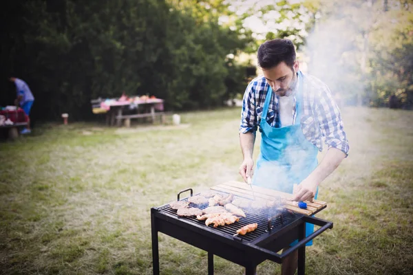 Handsome man grilling meat — Stock Photo, Image