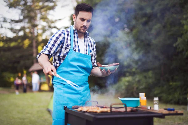 Przystojny mężczyzna grillowania mięsa — Zdjęcie stockowe