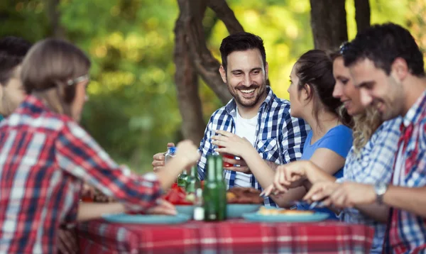 Amigos felizes desfrutando de churrasco — Fotografia de Stock