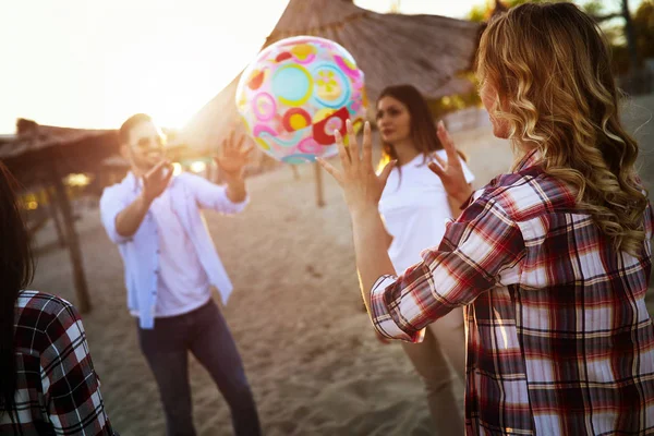 Jóvenes jugando con pelota en la playa — Foto de Stock