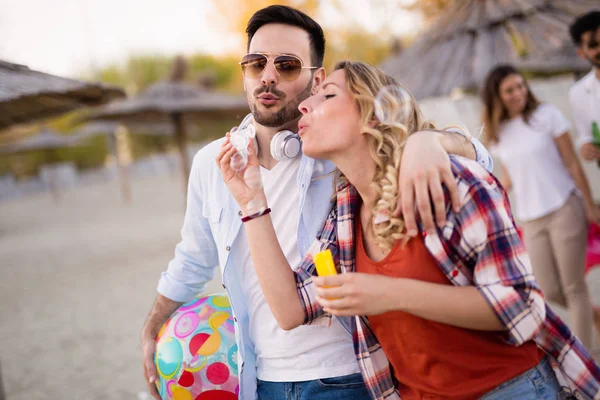 Amigos felizes festejando na praia — Fotografia de Stock