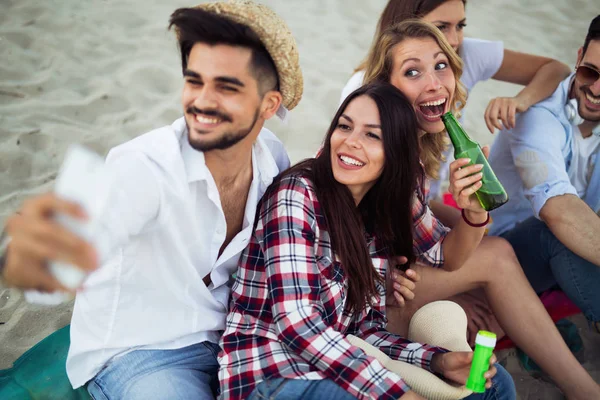 Jóvenes amigos divirtiéndose en la playa — Foto de Stock