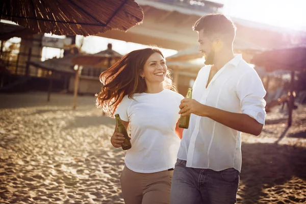 Felice coppia bere in spiaggia — Foto Stock