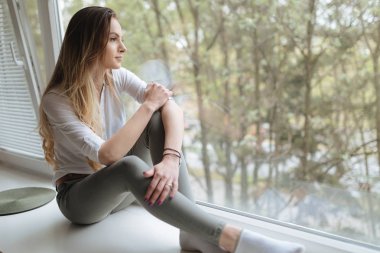 Pencere kenarında oturan kadın