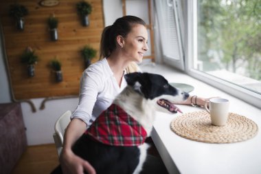 Bir kadın köpeğiyle vakit geçiriyor.