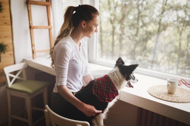 Bir kadın köpeğiyle vakit geçiriyor.