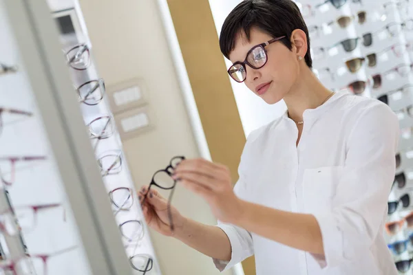 Mulher escolhendo novos óculos — Fotografia de Stock