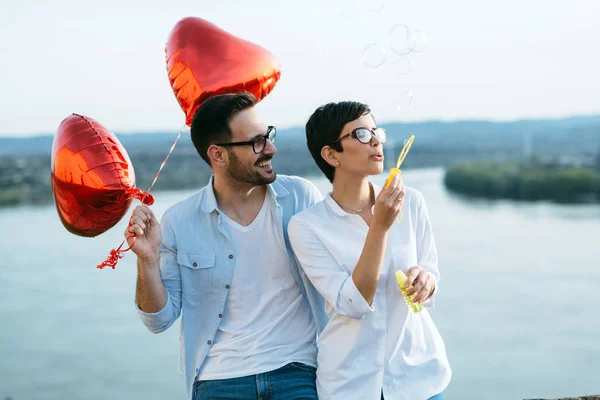 Usmívající se pár v lásce s balónky — Stock fotografie