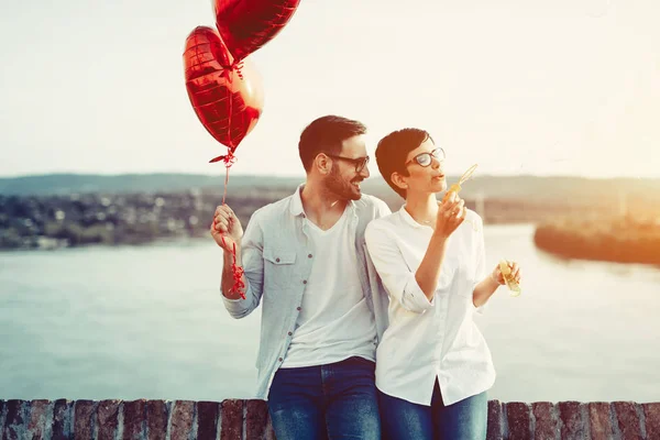 Pareja enamorada sosteniendo globos rojos —  Fotos de Stock