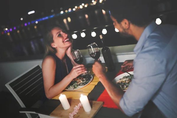 Joven hermosa pareja teniendo una cena romántica en la azotea — Foto de Stock