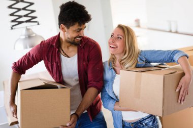 Genç çift yeni ev kavramı içinde hareket, karton kutuları açma