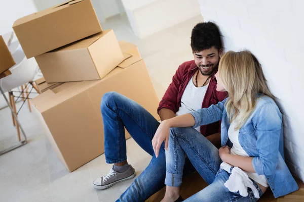 Genç çift yeni ev kavramı içinde hareket, karton kutuları açma — Stok fotoğraf