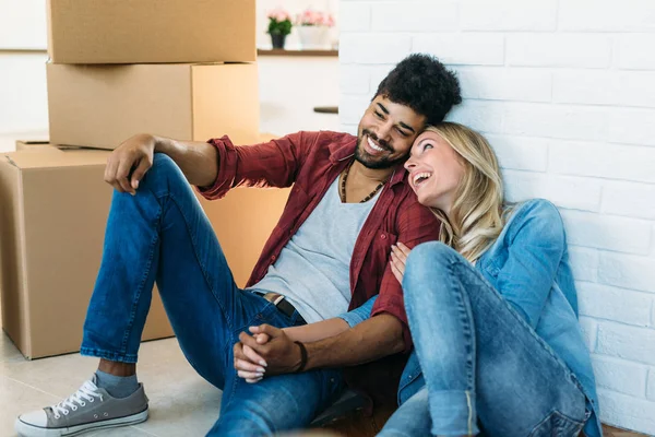 Casal jovem Movendo-se em nova casa e desembalando caixas de papelão — Fotografia de Stock