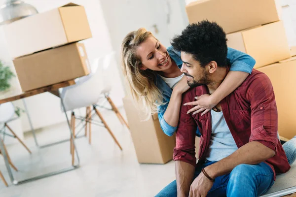 Young couple unpacking cardboard boxes at new home moving in concept — Stock Photo, Image