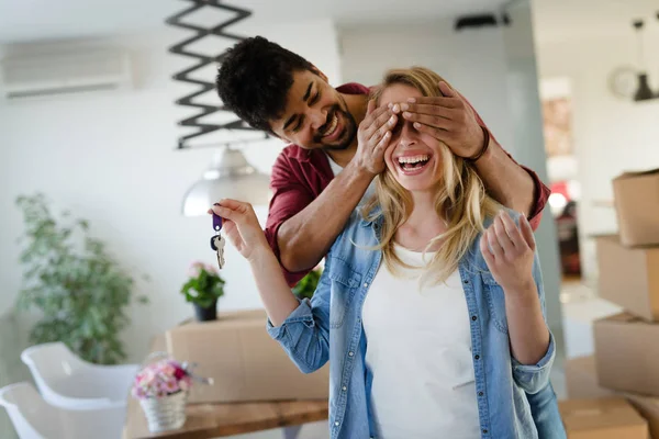 Casal jovem com caixas e segurando chaves planas — Fotografia de Stock