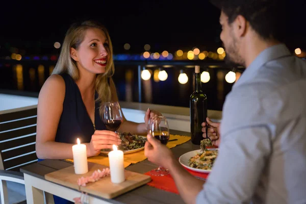 Joven hermosa pareja teniendo una cena romántica en la azotea — Foto de Stock