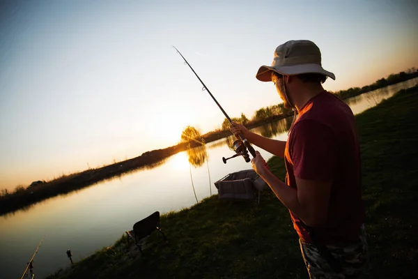 Los hombres que pescan en la puesta del sol y relajarse mientras disfruta de hobby — Foto de Stock