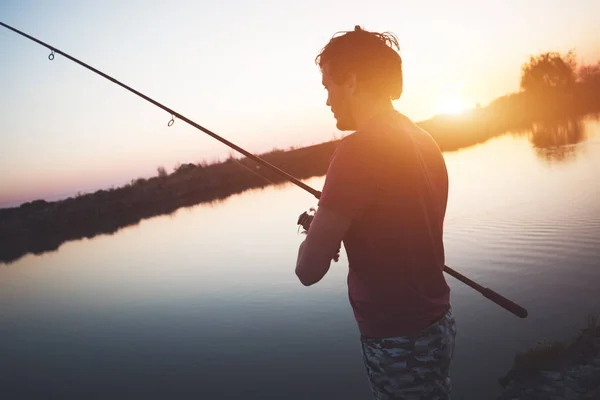 Joven pescando en el estanque y disfrutando de hobby —  Fotos de Stock