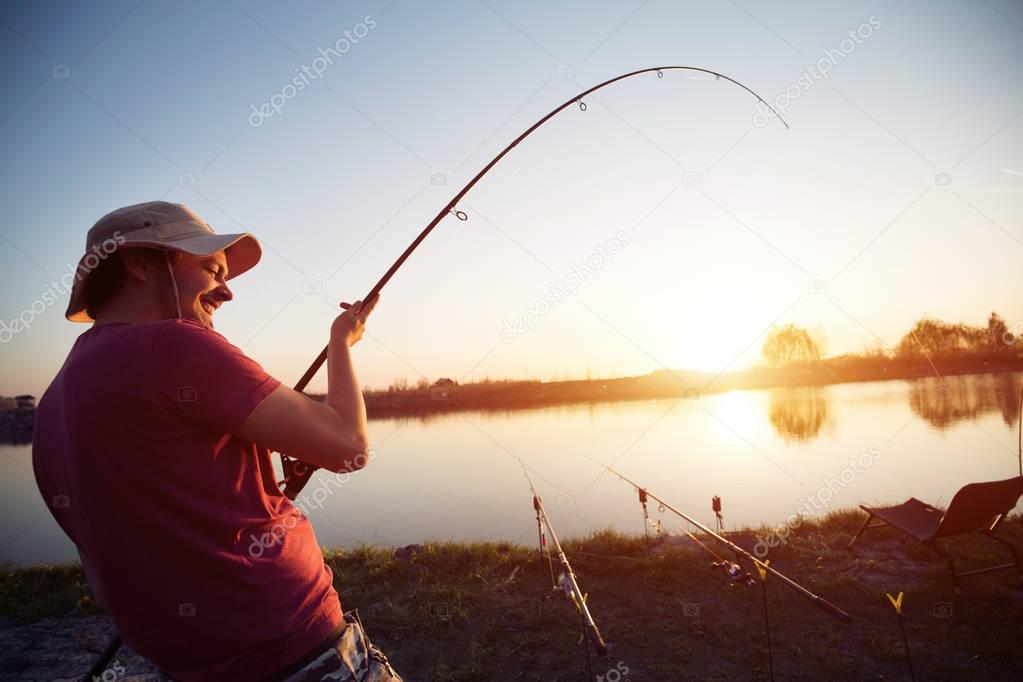 Fishing as recreation and sports displayed by fisherman at lake