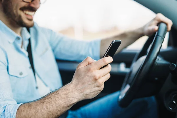 Hombre usando el teléfono mientras conduce el coche — Foto de Stock