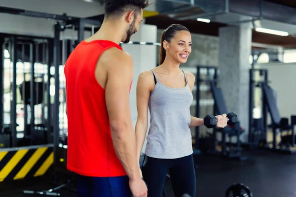 Mujer haciendo ejercicio en el gimnasio con entrenador —  Fotos de Stock