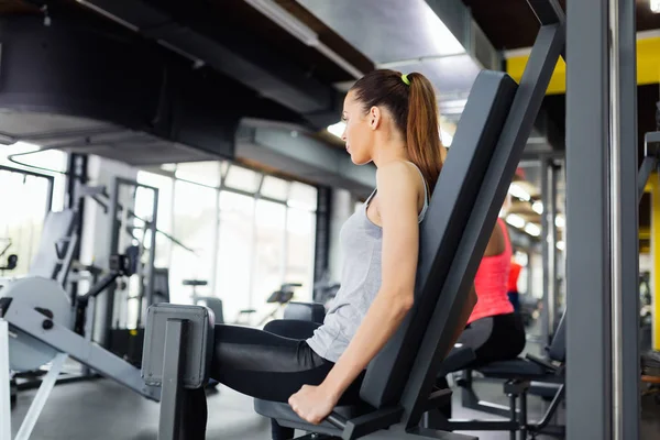 Mujer joven haciendo ejercicio en el gimnasio —  Fotos de Stock