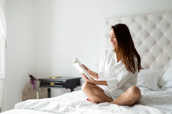 Mujer en la cama libro de lectura —  Fotos de Stock