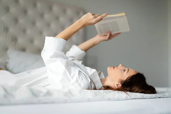 Mujer en la cama libro de lectura —  Fotos de Stock