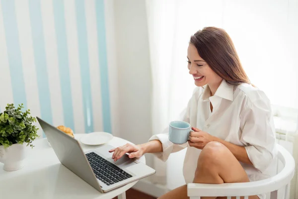 Mujer usando el ordenador portátil y beber café —  Fotos de Stock