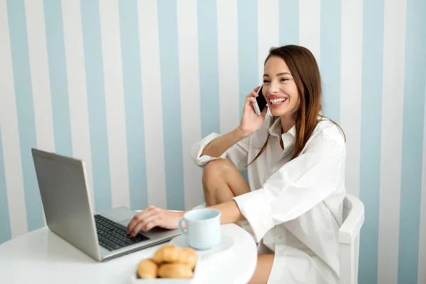 Donna che utilizza laptop e telefono cellulare — Foto Stock