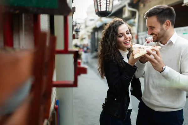 Pareja compartiendo un corte de pizza — Foto de Stock