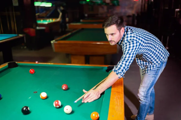 Hansome man playing pool in bar