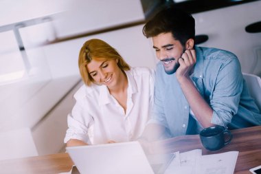 dizüstü bilgisayarda çalışan kadın ve erkek