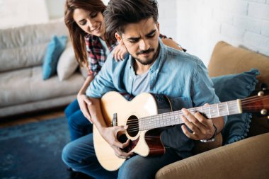 Adam kız arkadaşı için gitar çalıyor.