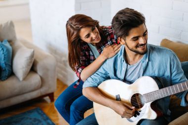 Adam kız arkadaşı için gitar çalıyor.