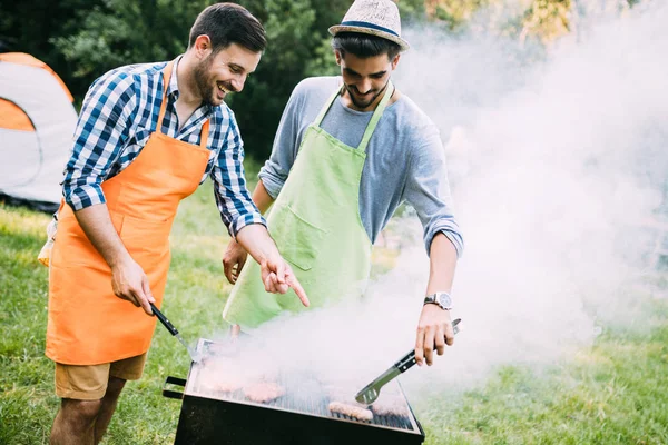 Vrienden doorbrengen van tijd in de natuur en met barbecue — Stockfoto
