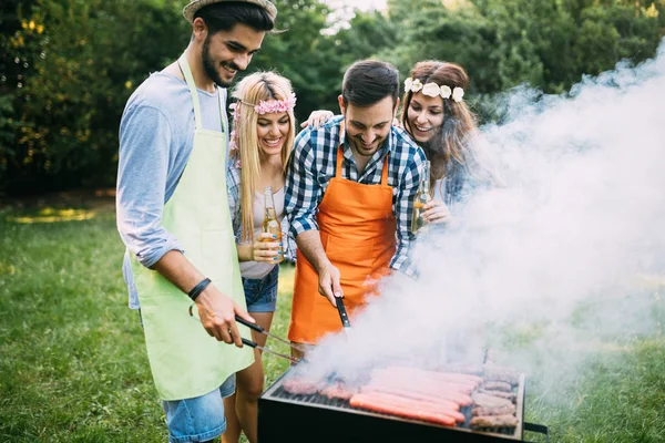 Amigos gastando tempo na natureza e fazendo churrasco — Fotografia de Stock