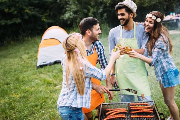 Amigos gastando tempo na natureza e fazendo churrasco — Fotografia de Stock