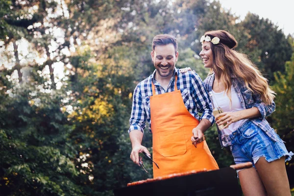 Vakker kvinne og kjekk mann som griller. – stockfoto