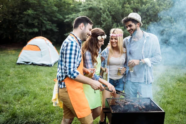 Amici trascorrere del tempo nella natura e fare barbecue — Foto Stock