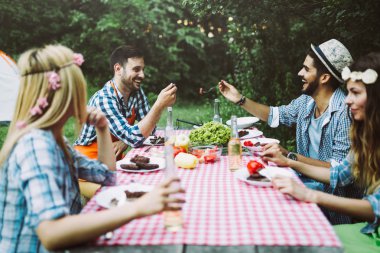 Masada oturan ve yemek neşeli arkadaşları
