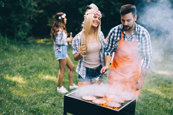 Amici trascorrere del tempo nella natura e fare barbecue — Foto Stock